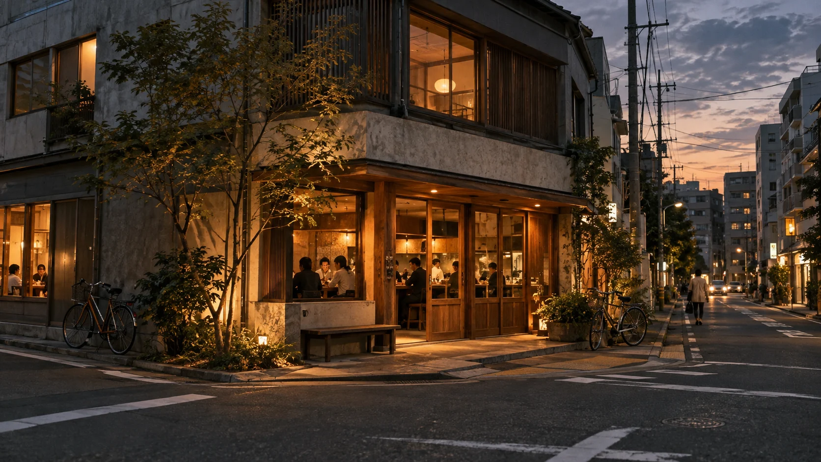 自転車が行き交う街角に、暖かい明かりを灯す飲食店